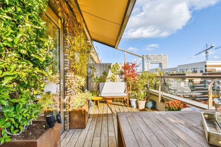 a balcony with plants and pots on the wooden deck, in front of an apartment building under construction cranes are visible in theの写真素材