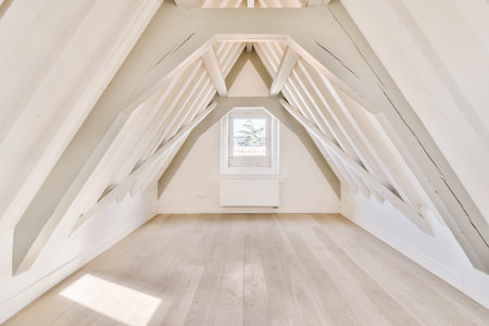 an attic room with white walls and wooden floors, all painted in the same color as natural wood flooringの写真素材