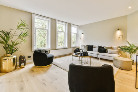 a living room with two couches and a large plant in the center of the room there is a white rug on...