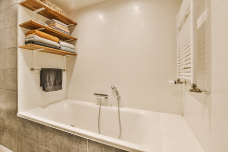 a bathroom with some shelves on the wall and a bathtub in the corner next to the tub is whiteの写真素材