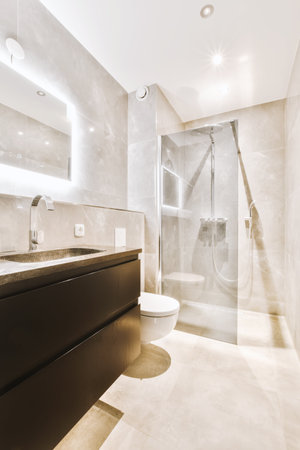 a modern bathroom with white marble walls and flooring, along with a walk - in shower on the right...