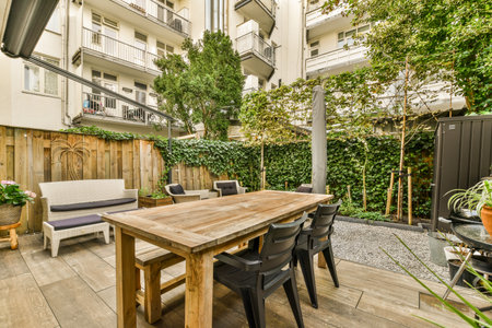 an outdoor patio area with furniture and plants in the back yard, surrounded by tall green trees on...