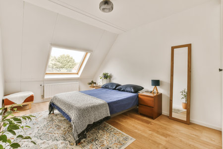 a bedroom with white walls and wood flooring, including a blue bed in the room is surrounded by a...