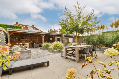 a backyard area with some plants and flowers on the table, chairs and bench in the background is...