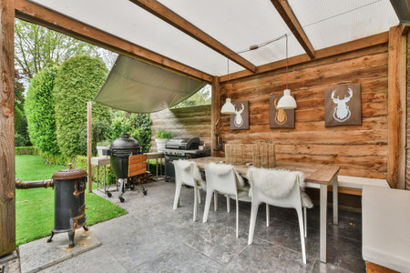 Amsterdam, Netherlands - 10 April, 2021: an outdoor kitchen with white chairs and grilling equipment on the outside patio, which is covered in wood planksのeditorial素材