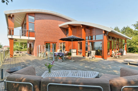 a house that looks like its made out of red brick and wood, with an umbrella on the patioのeditorial素材