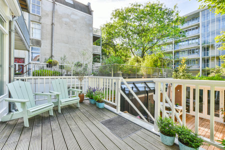 Amsterdam, Netherlands - 10 April, 2021: a deck with green chairs and trees in the back yard at an apartment building, london, united - stock photoのeditorial素材