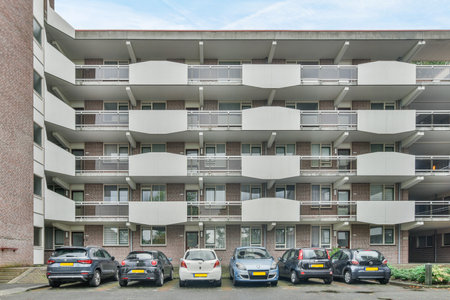 some cars parked in front of an apartment building with balks on the windows and balks on the second floorのeditorial素材