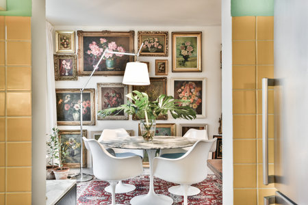 Amsterdam, Netherlands - 10 April, 2021: a living room with pictures on the wall and a round table in front of it that is surrounded by white chairsのeditorial素材
