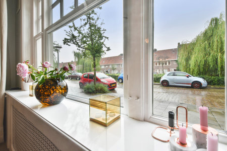 Amsterdam, Netherlands - 10 April, 2021: a brick building on the side of a street with cars parked in front and trees lining the sidewalk behind itのeditorial素材