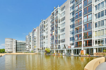 some buildings on the side of a body of water with an umbrella in its hand and people walking byのeditorial素材