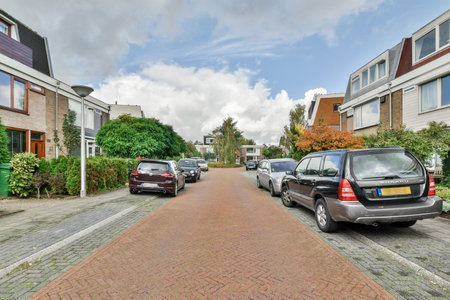 Amsterdam, Netherlands - 10 April, 2021: a street with cars parked on the side and houses in the backgrunde, netherlands - stock photoのeditorial素材