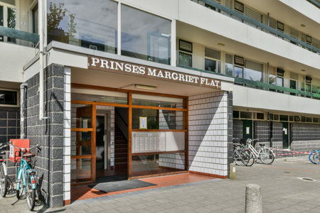 an apartment building with bicycles parked in the front and on the sidewalk next to it is a sign that says pines marketのeditorial素材