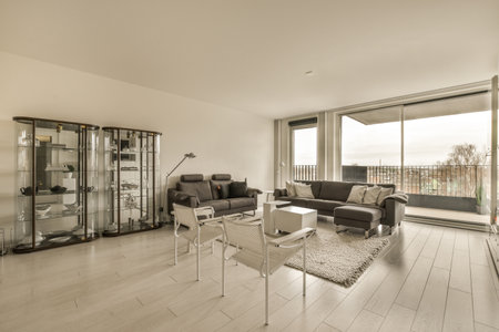 a living room with white walls and wood flooring in the center of the room, there is a glass sliding...