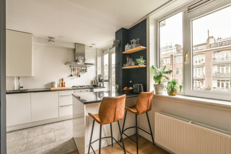 a kitchen area with two chairs and a table in front of the window looking out to the street below itの写真素材