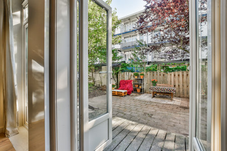 an outside area with wood flooring and sliding glass doors that open to the backyard, looking out...