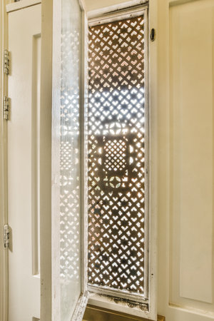 the inside of a bathroom with a shower stall in its corner and an open door leading to another roomの写真素材
