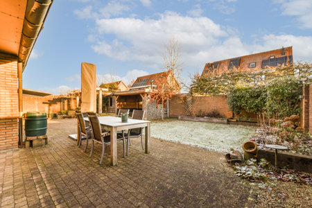an outside area with a table, chairs and pots on the ground in front of a brick wall that has been...