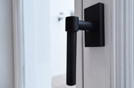 a door handle on the side of a white building with an open window in the photo is blurred and blurryの写真素材