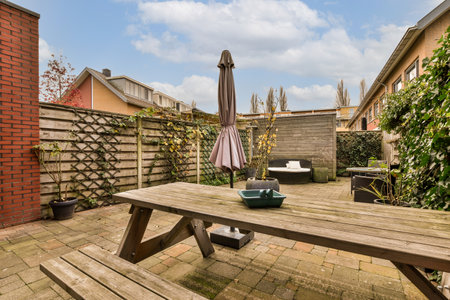 a backyard setting with a picnic table and umbrellas on the deck, in front of an outdoor patio areaの写真素材