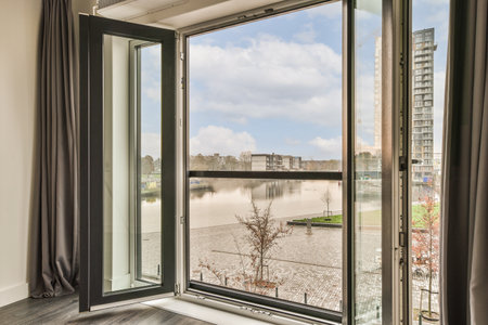 a room with a view of the water from its window sing out to the street and buildings in the distance