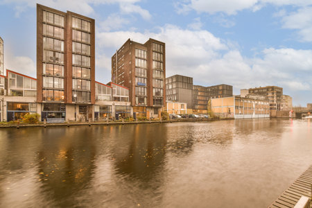 an urban area with buildings and water in the fore, as seen from a moving train on a cloudy dayの写真素材