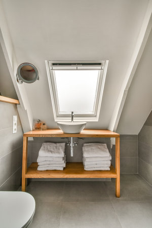 a bathroom with two towels on the shelf and a toilet in the other side of the bathtub is visible