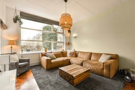 a living room with a couch and coffee table in front of a large window looking out onto the street...