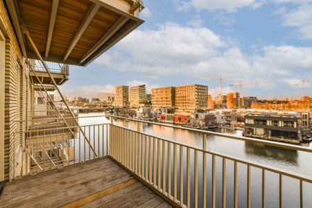 some buildings and boats on the water from a balcony in an apartment building with wooden railings, overlooking out onto the riverの写真素材