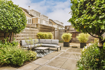 an outdoor living area with patio furniture and plants in the fore - image is taken from outside, no...