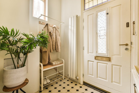 a bathroom with a plant in the corner and a mirror on the wall above it, next to a white doorの写真素材