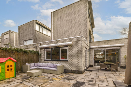 a backyard area with a couch, table and some buildings on the other side of the building is made out...