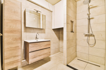 a bathroom with wooden cabinets and white tiles on the walls, along with a walk - in shower stall...