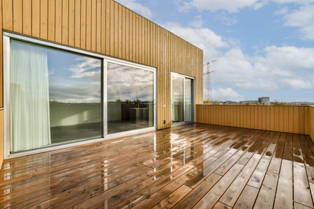 an outside area with wood flooring and sliding glass doors that open up to the view out onto the skyの写真素材