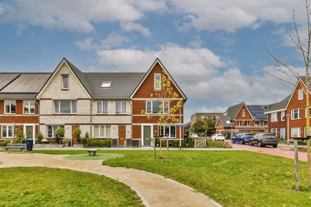 some houses on a sunny day with blue sky and white clouds in the background photo is taken from an angleers perspectiveの写真素材