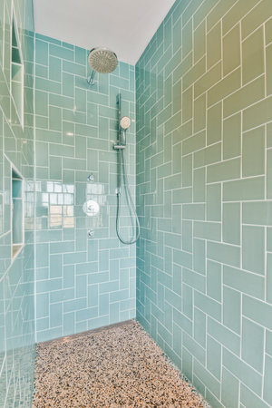 a bathroom with blue and white tiles on the walls, shower head in the corner to the floor is made...