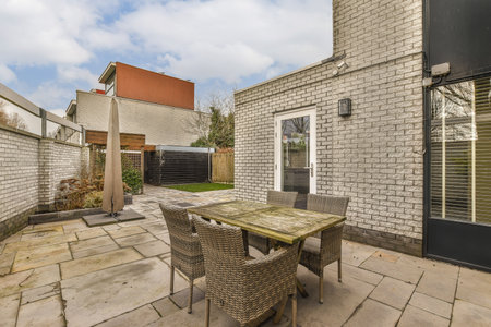 a patio with some chairs and a table in front of a brick wall that looks like its from the outside