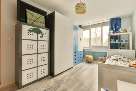 a kids room with white walls and wood flooring on the wall, there is a toy storageの写真素材