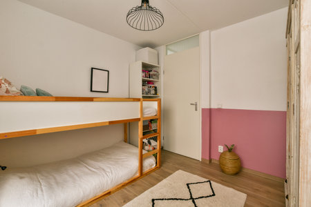 a kids room with bunks and pink accent on the wall in the childrens bedroom areaの写真素材