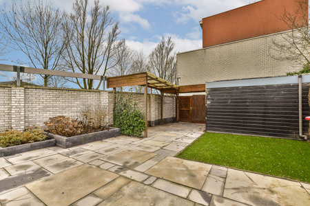 a backyard area with a fence and some trees in the back yard on a sunny, blue sky day that is...