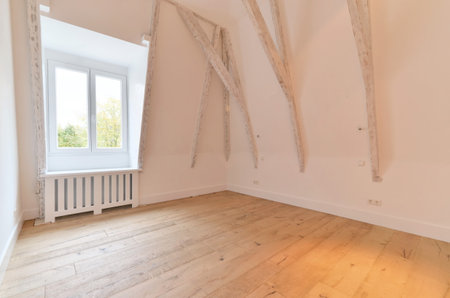 an empty room with wood flooring and wooden beams on the walls, in front of a window that looks out...