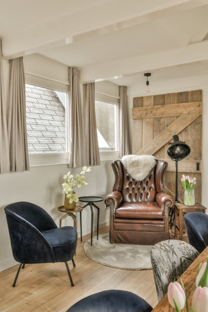 a living room with two chairs and a coffee table in front of the couch is on the right side of the...