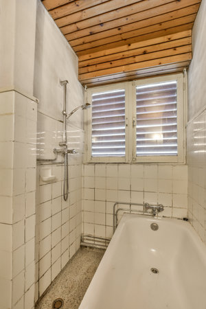 a bathroom with a bathtub and shower stall in the corner, all made out of white ceramic tiles on the...
