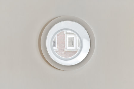 a round window in a wall with a brick pattern on the top and bottom part of the circle is whiteの写真素材