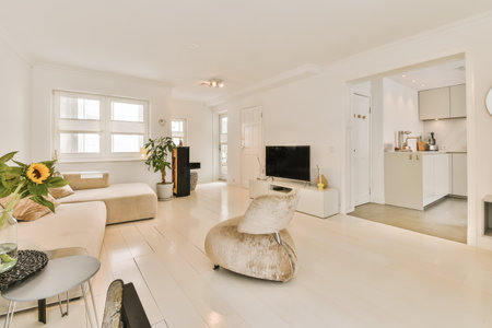 a living room with white walls and wood flooring in the center of the room, there is a large mirror...