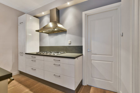 a kitchen with white cupboards and black counter tops on the counters in this photo is taken from...