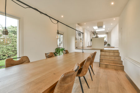 a dining table and chairs in a room with an open window looking out onto the garden outside on a...