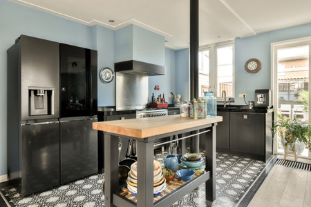 a kitchen with black and white tiles on the floor next to an open door that leads to a large windowの写真素材