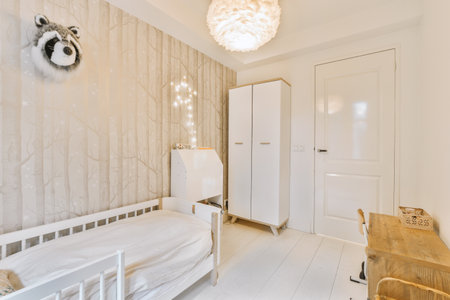 a bedroom with white furniture and wallpapers on the walls there is a small bed in front of itの写真素材