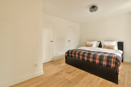 a bedroom with white walls and wood flooring in the fore - image is taken from above the bed...
